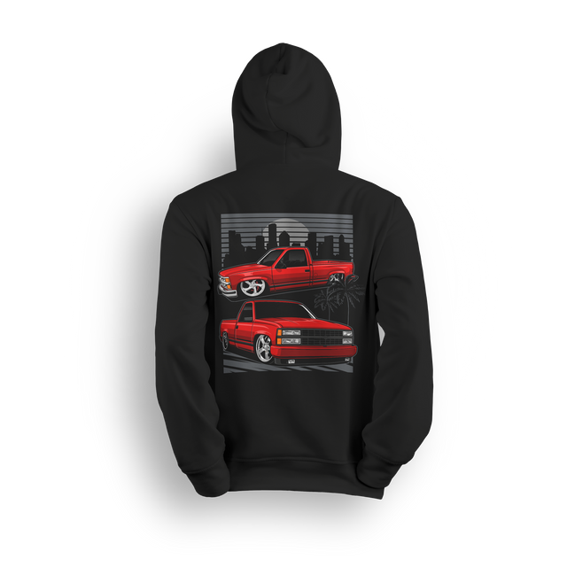 Hoodie with two red OBS trucks, city skyline, palm trees, and low stance. Design captures the sunset cruise truck scene.