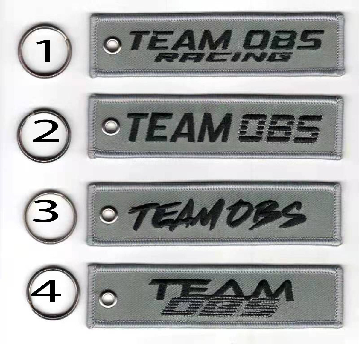 Team OBS flight tag keychains in grey with embroidered logos and metal keyrings