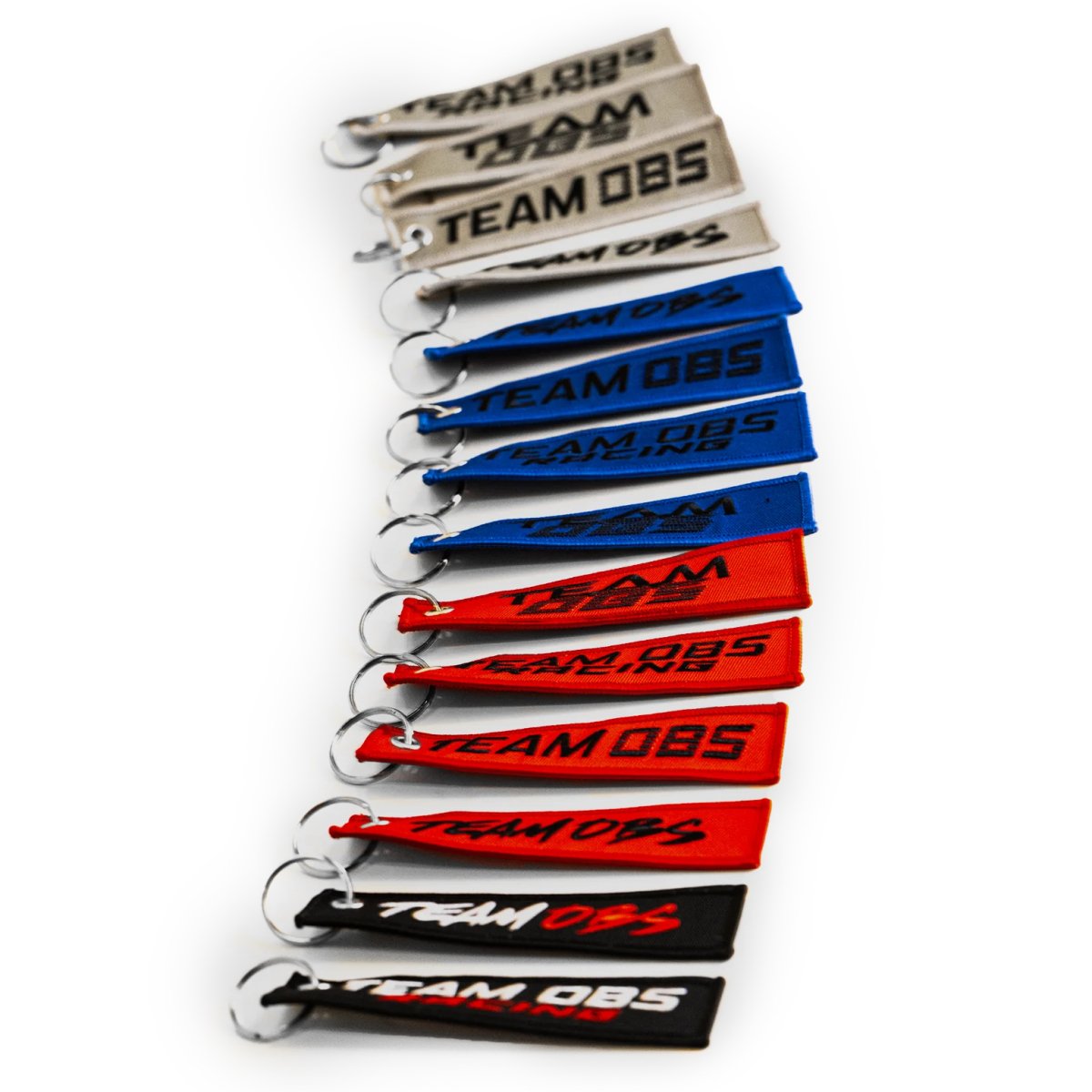 Team OBS flight tag keychains in multiple colors with embroidered logos and metal keyrings