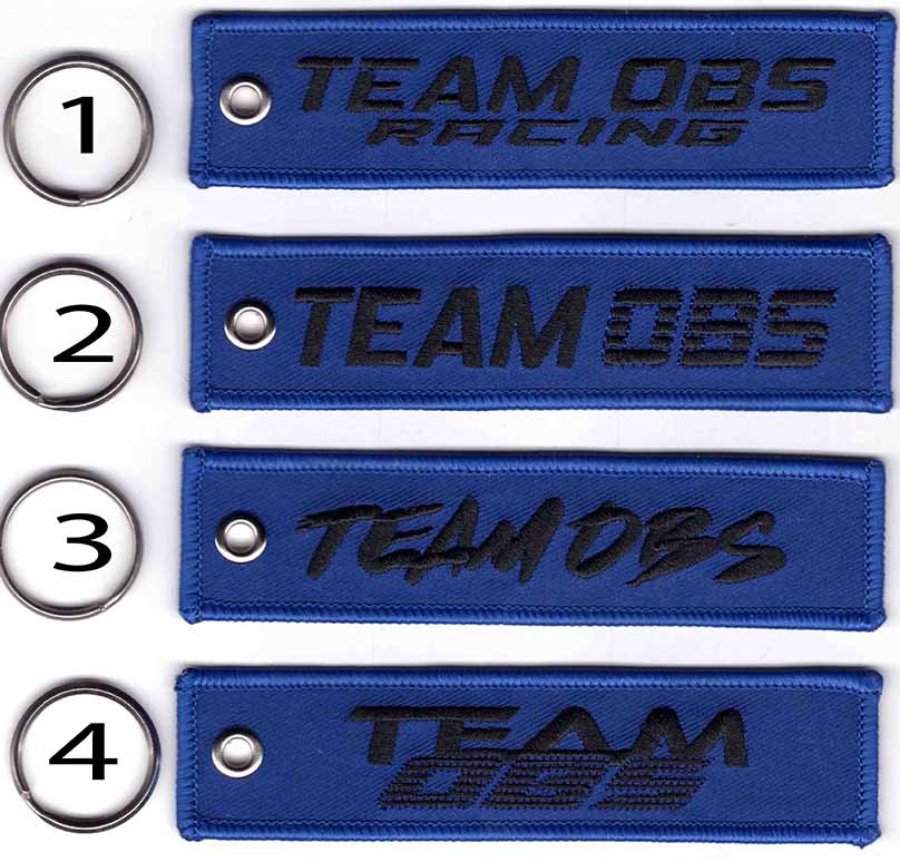 Team OBS flight tag keychains in blue with embroidered logos and metal keyrings