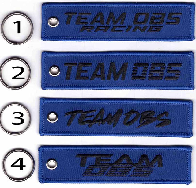 Team OBS flight tag keychains in blue with embroidered logos and metal keyrings